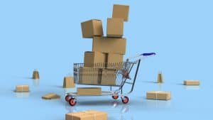 Shopping cart with cardboard boxes and scattered packages on blue background.
